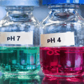 Laboratory jars showing pH testing of industrial wastewater liquids